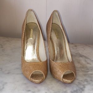 Gold canvas stiletto heeled red bottomed shoes.